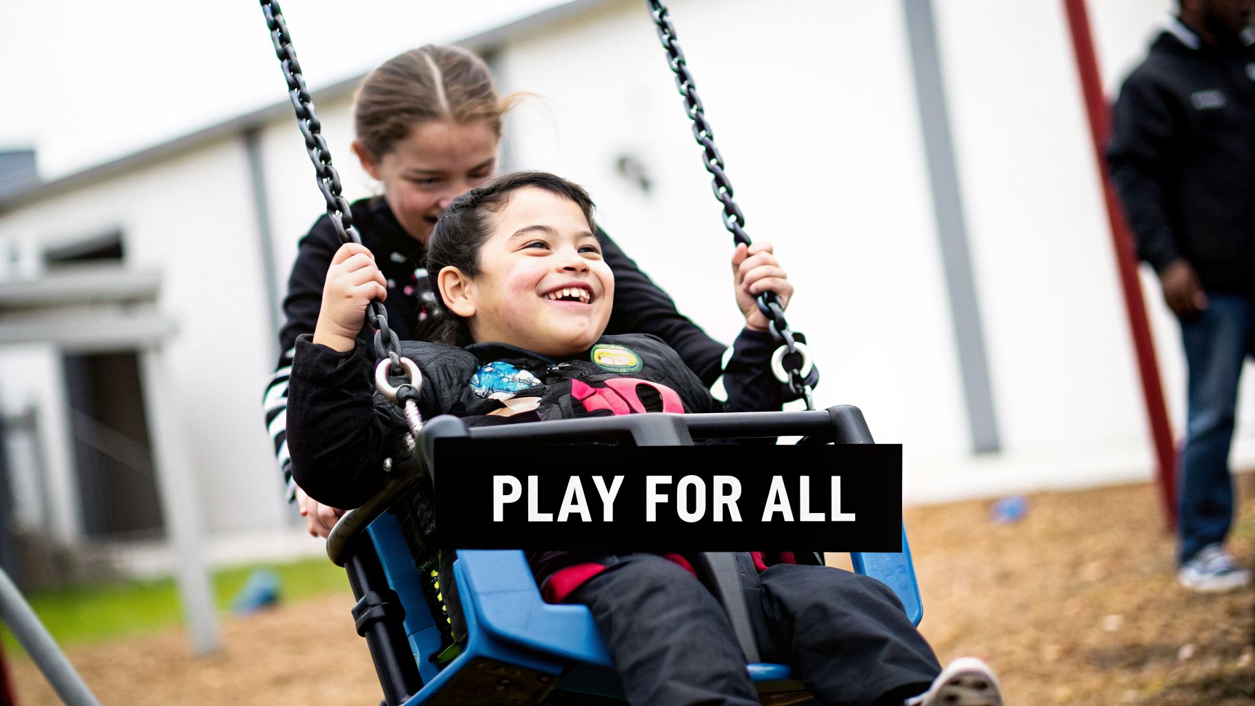 A happy girl with a disability laughs joyfully on a specialized swing, pushed by another girl.