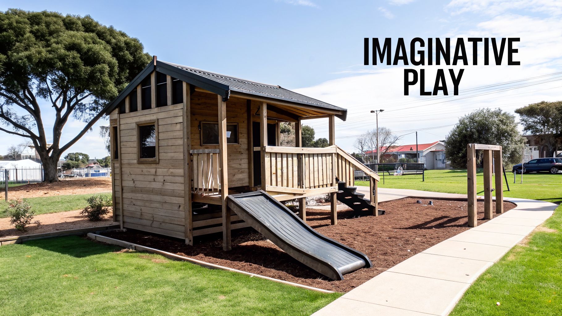 A rustic timber cubby house with a porch and slide, set in a sunny park on a bright day.