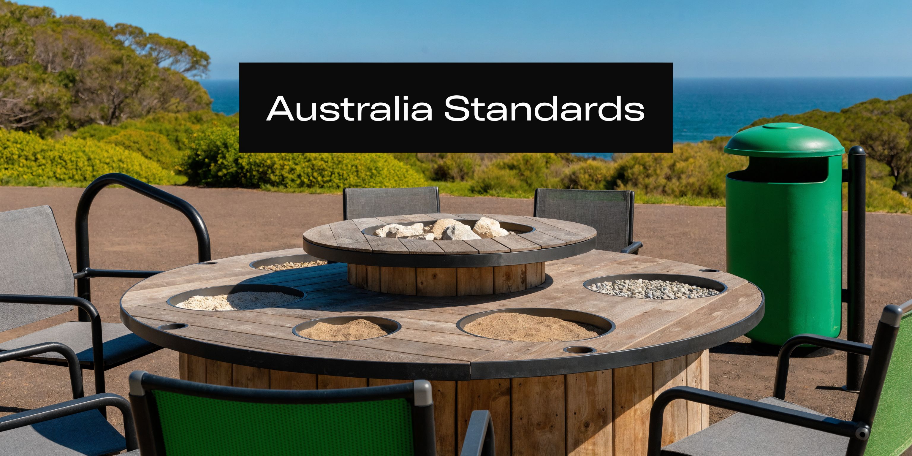 A wooden circular outdoor table featuring integrated sand and stone basins for a sensory play station.