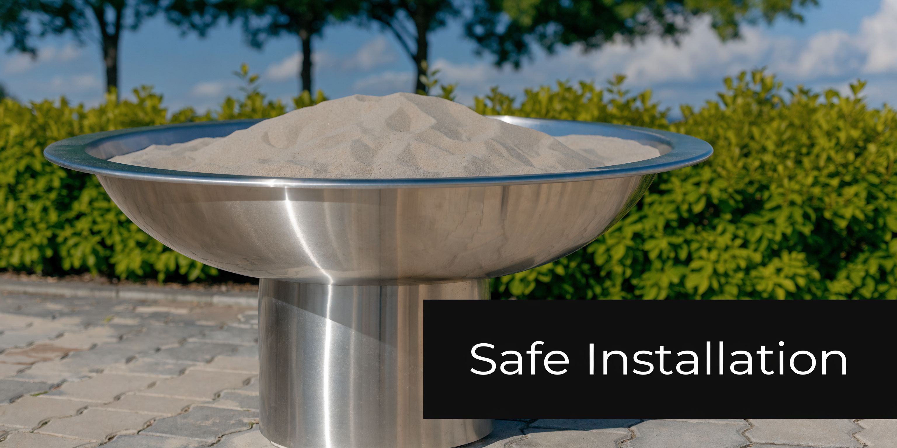 A modern stainless steel bowl filled with clean sand sits outdoors, highlighting safe installation for a sandbox.